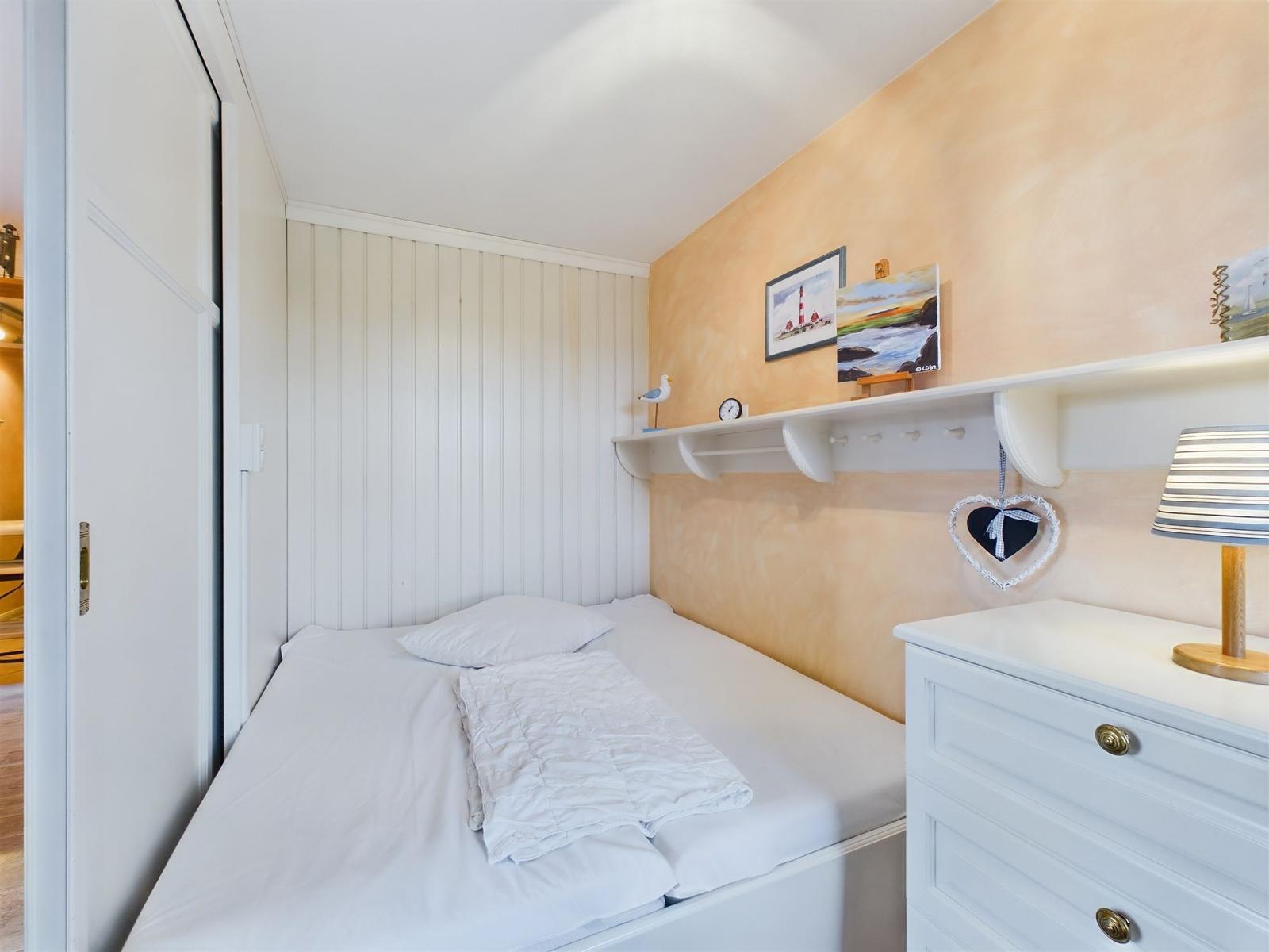 Holzweg führt zu einer modernen Ferienwohnung inmitten von Gras und Bäumen.