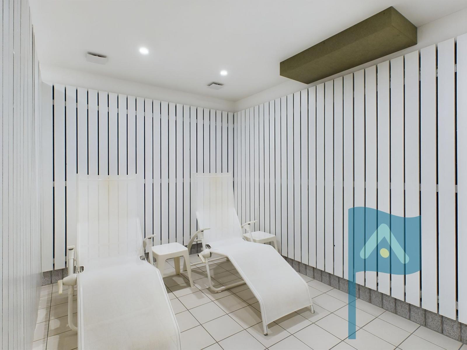 Sauna mit Holzbanken und Thermostaten an der Wand.