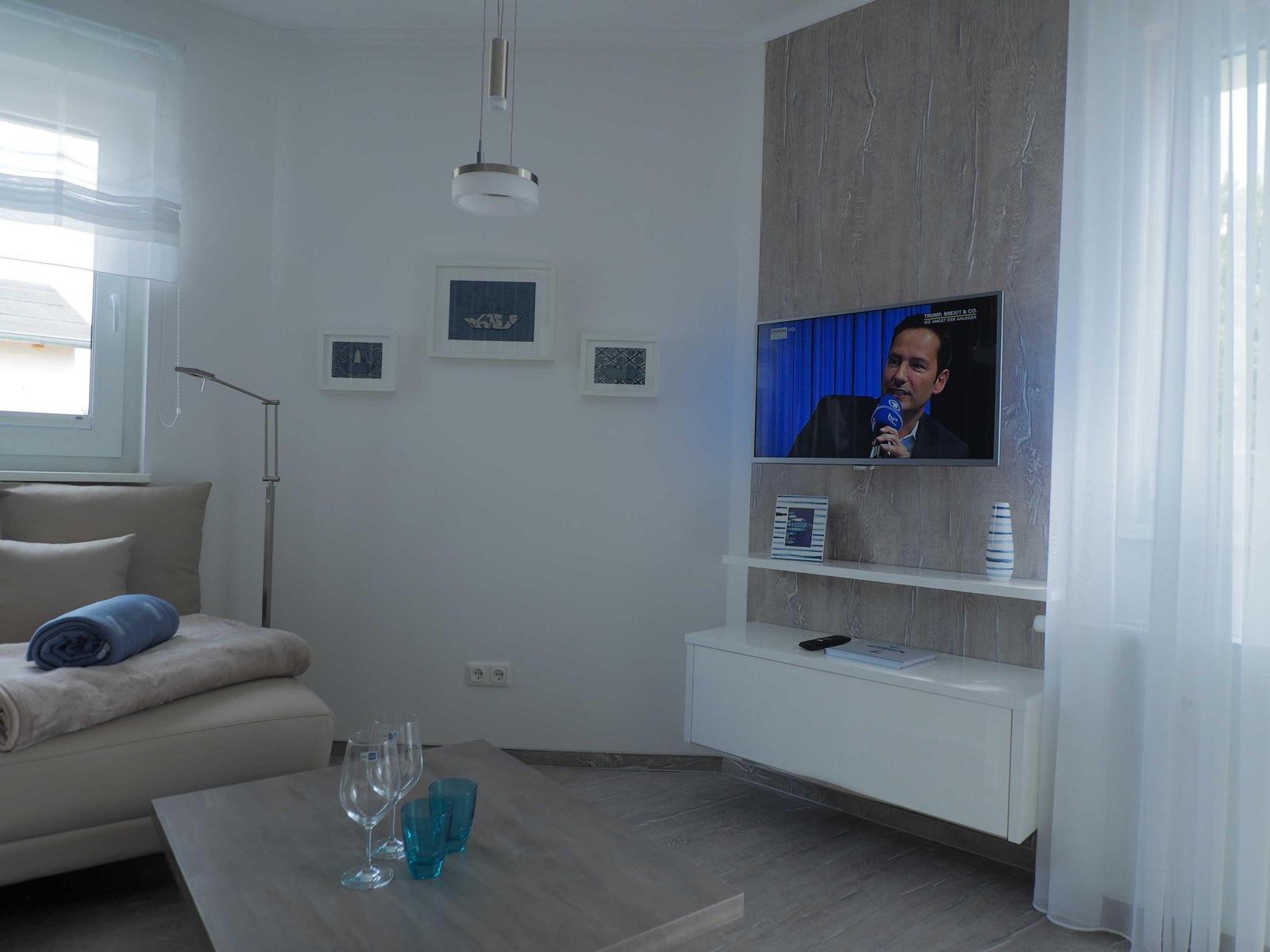 Zweizimmer-Wohnung mit Küche, Bad und Terrasse mit Sonnenschirm.