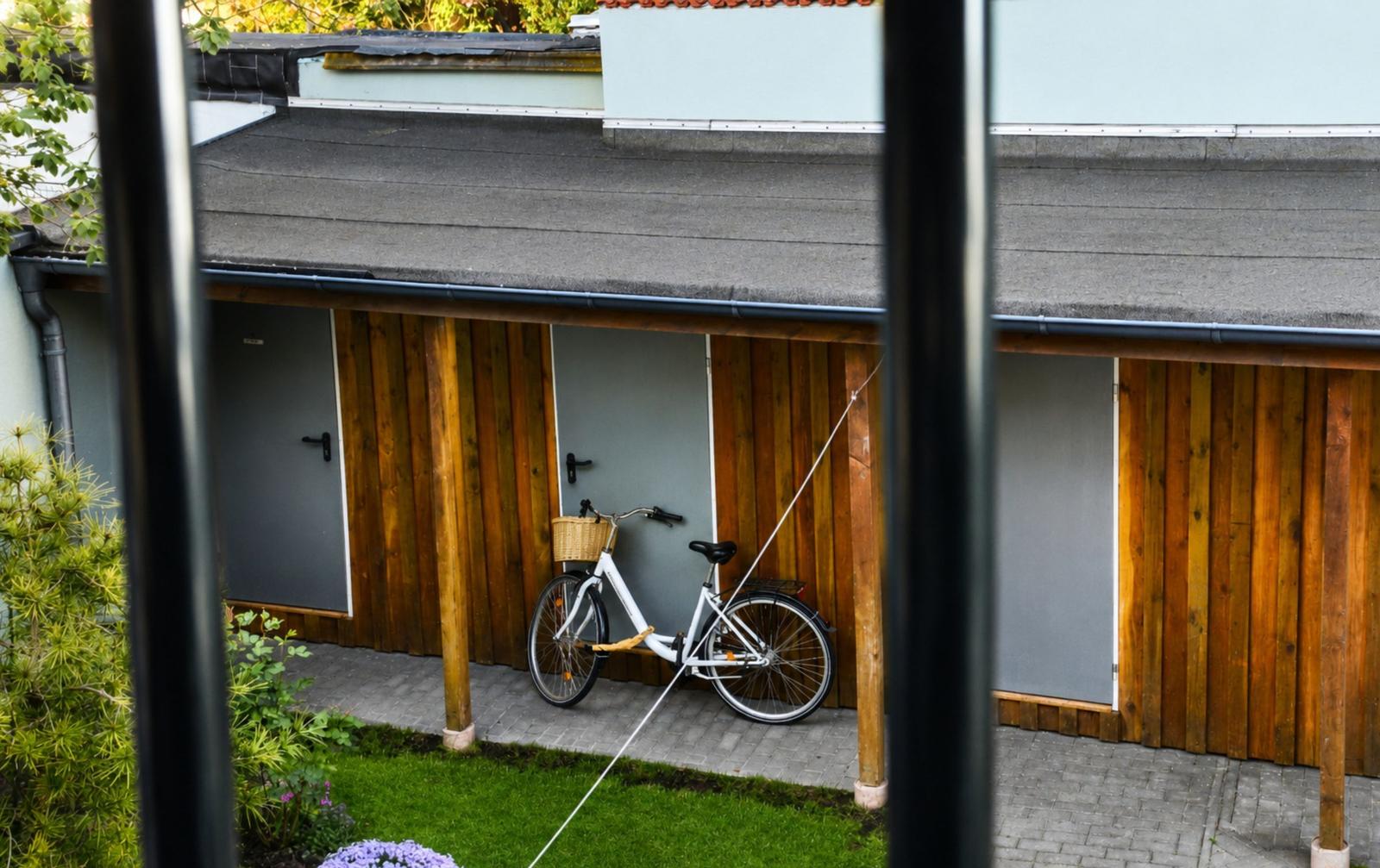 Ein grünes Haus mit Balkonen, die mit Pflanzen und Möbeln eingerichtet sind.