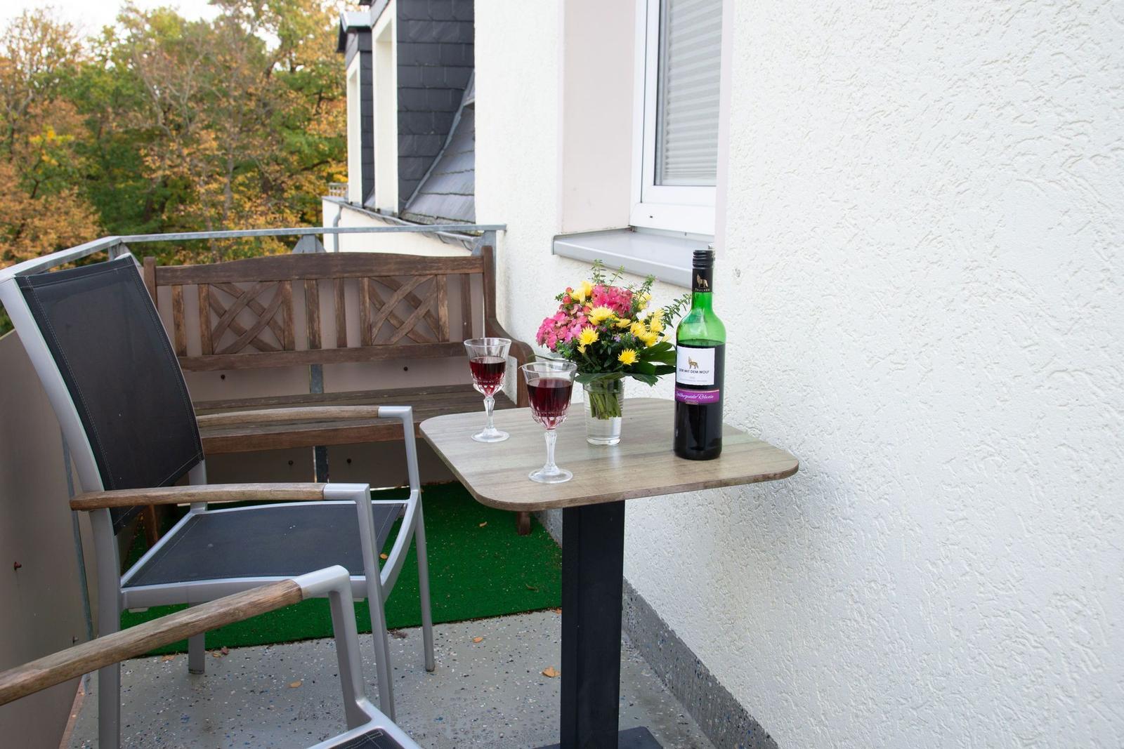 Wohnzimmer mit Sofa, Couchtisch, Fernseher und Fenster mit Vorhängen.