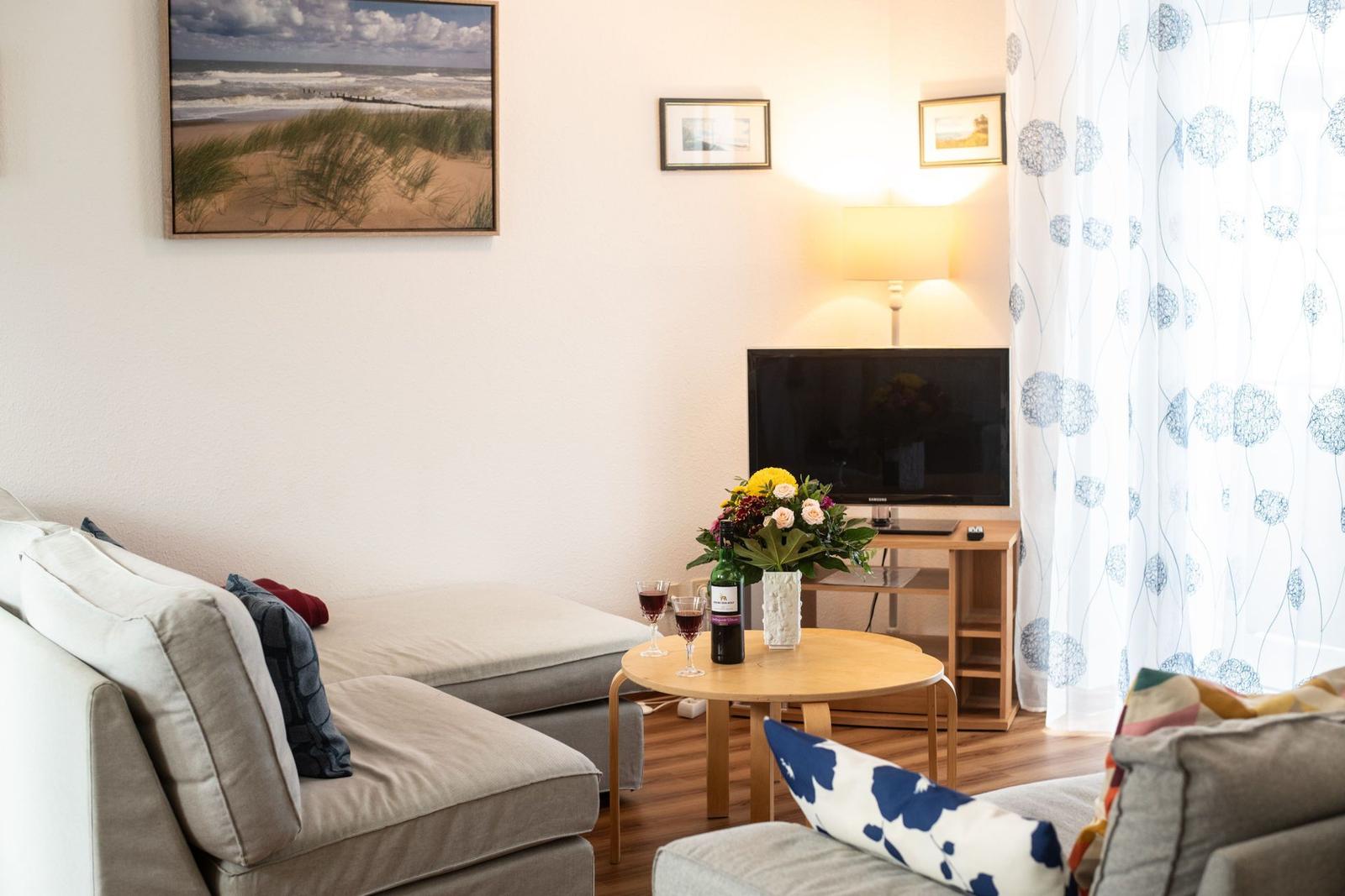 Zimmer mit zwei Betten, Fenster, TV und Handtuchständer.