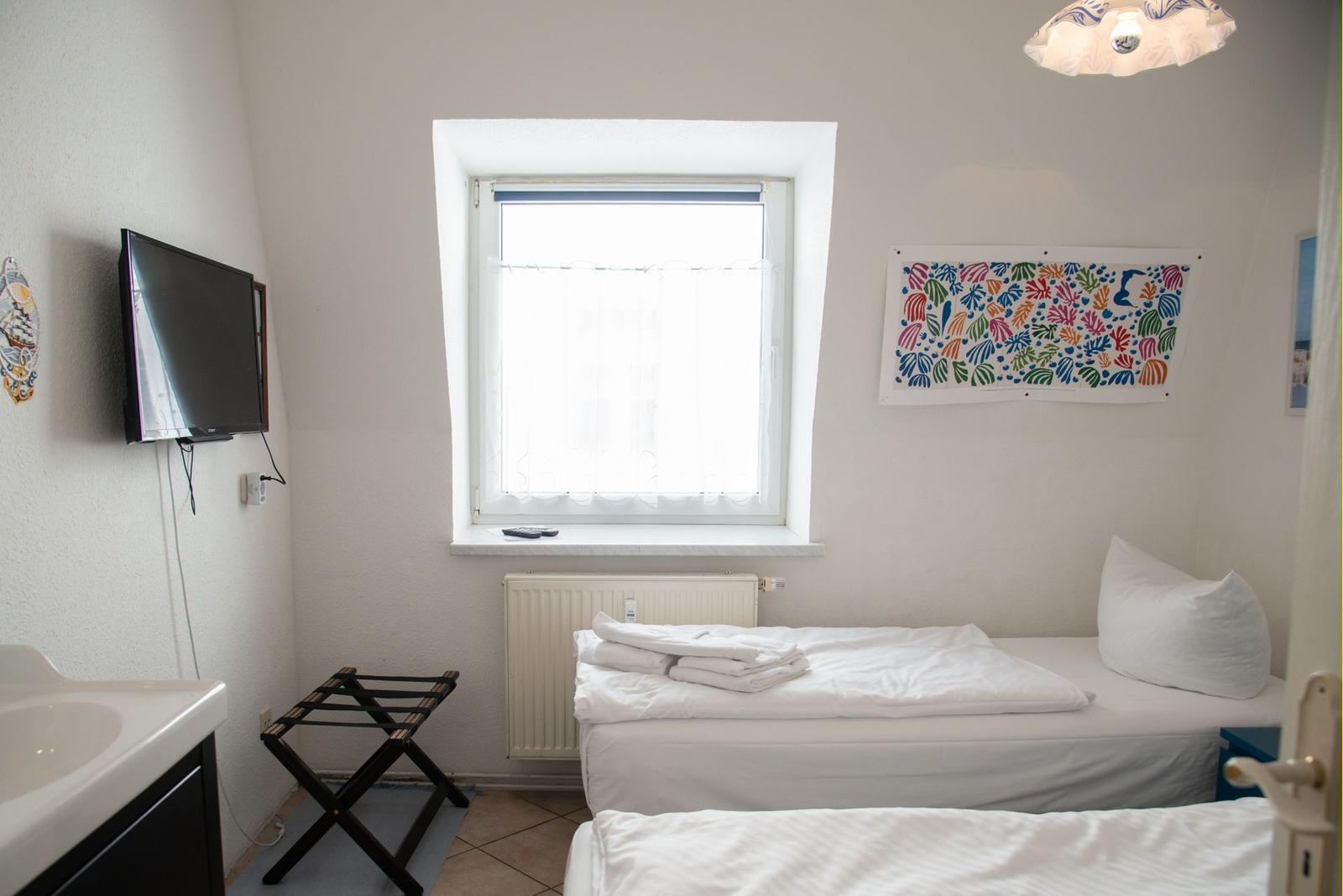 Wohn- und Küchenbereich mit Sofa, Küchenzeile und Holzboden.