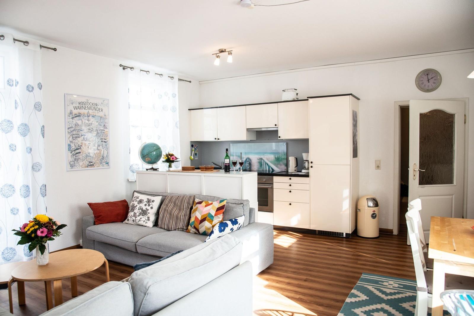 Schlafzimmer mit Bett, Kleiderschrank und Fenster mit Vorhängen.