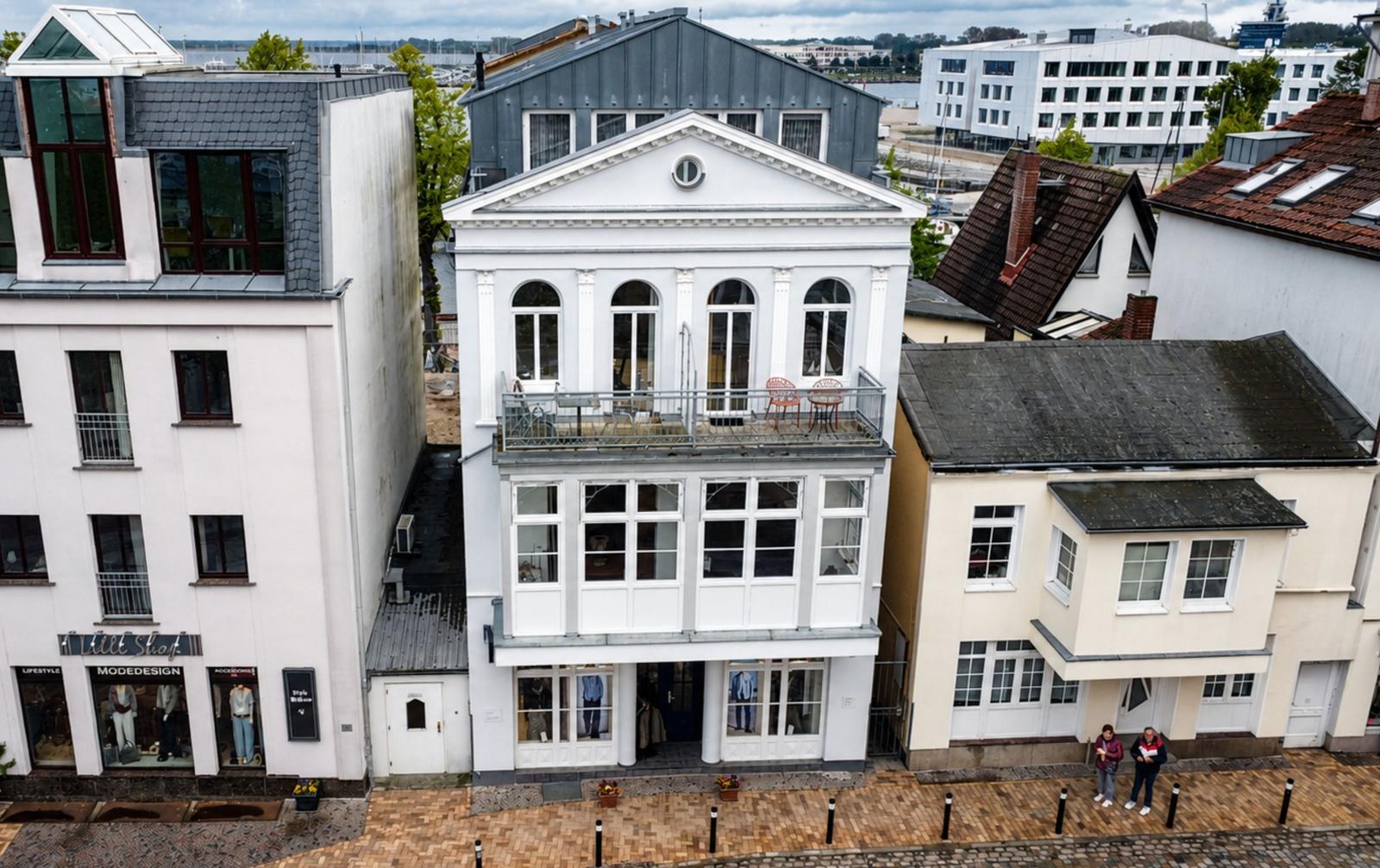 Aussicht auf historische Gebäude mit Dächern und gepflasterten Straßen aus der Vogelperspektive.