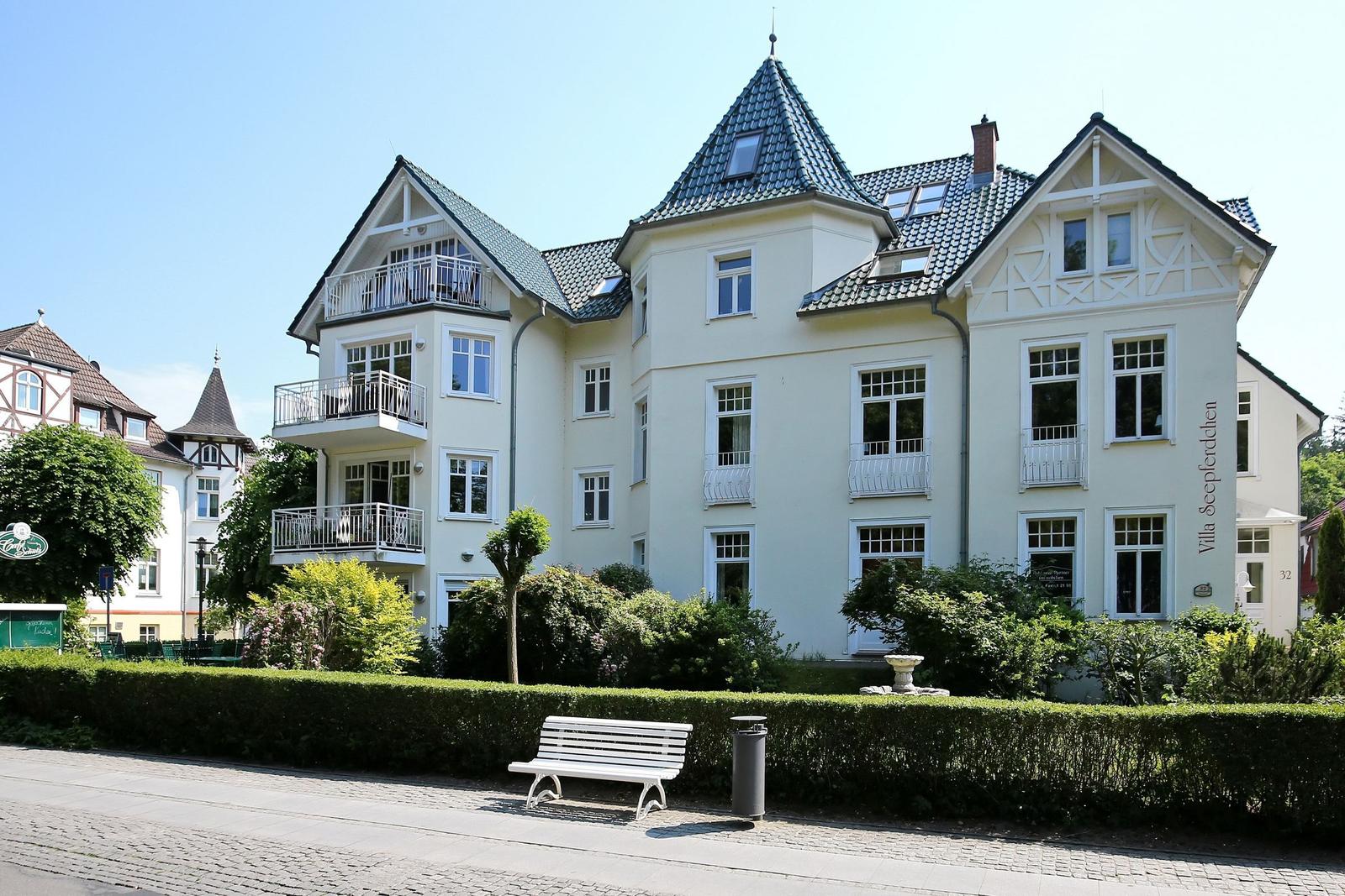 Villa mit Balkonen und grüner Umgebung in städtischer Lage