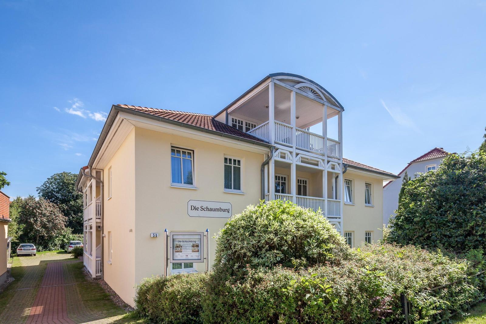 Die Schaumburg, ein zweistöckiges Haus mit Balkon und Garten.