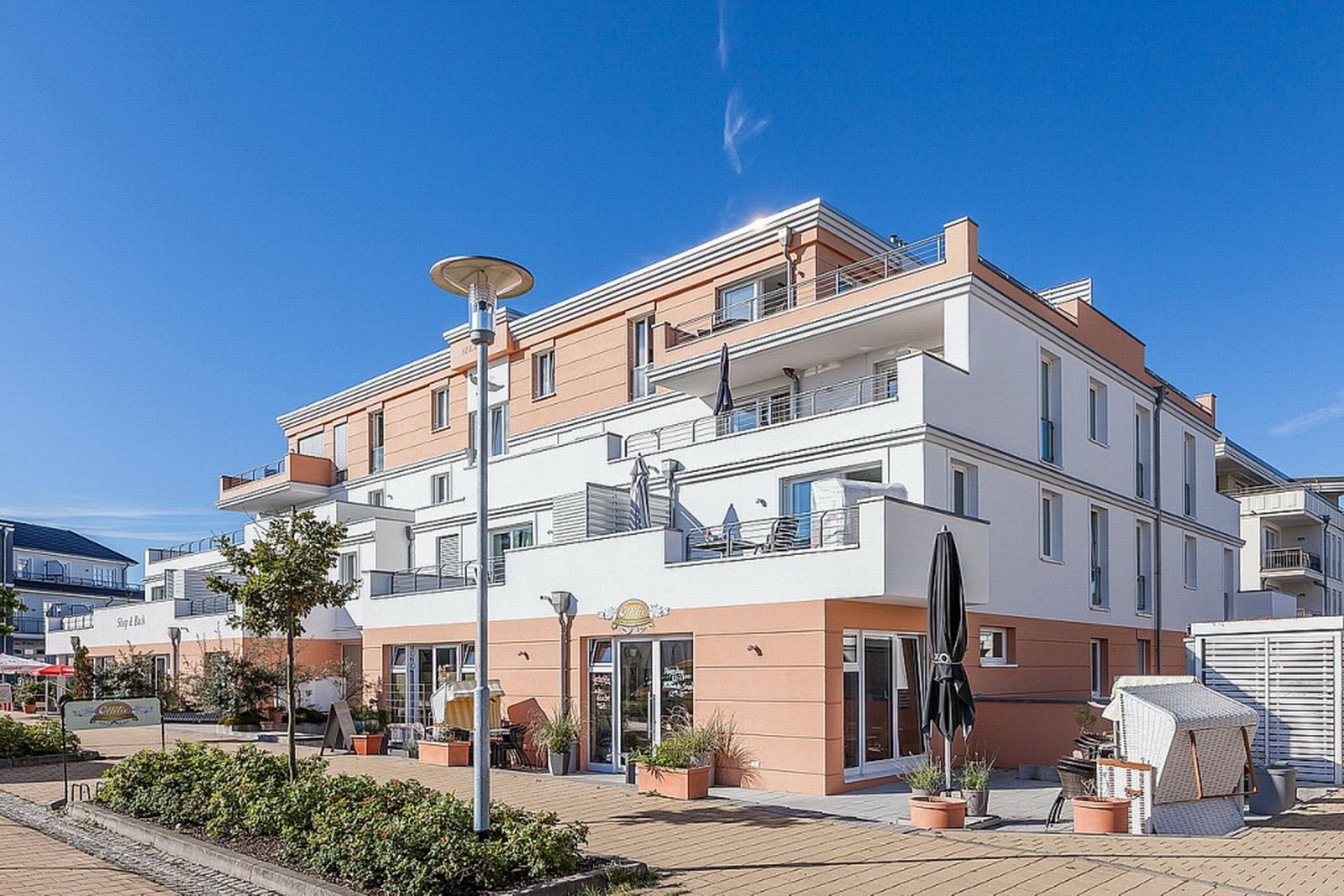 Modernes Mehrfamilienhaus mit Balkonen und Terrassen im Freien.