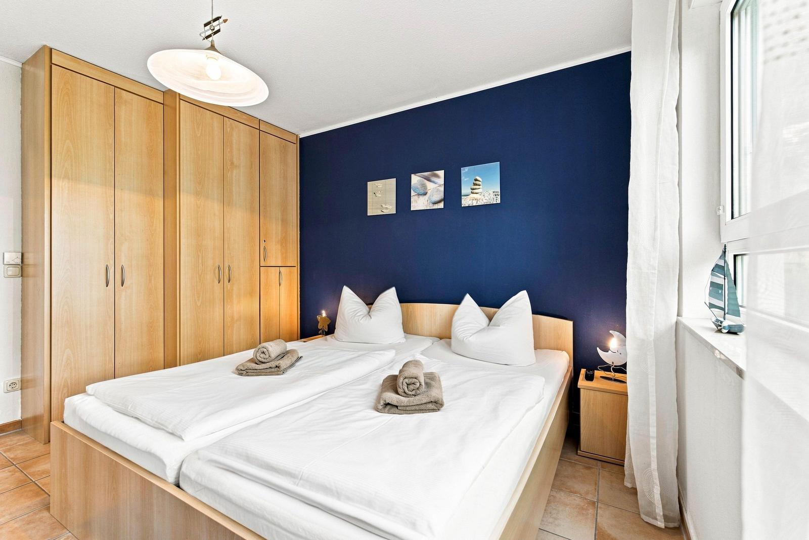 Schlafzimmer mit Doppelbett, Kleiderschrank und TV
