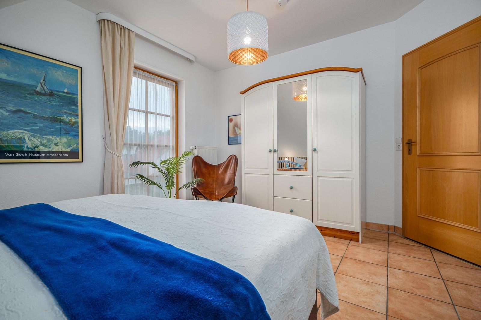 Schlafzimmer mit Doppelbett, Babybett und TV