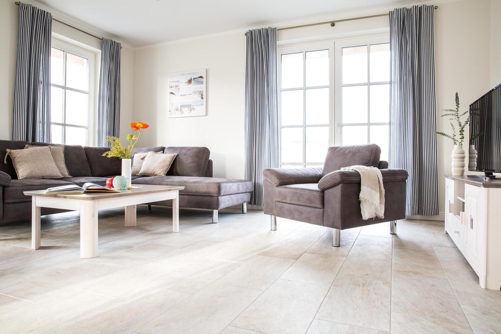 Schlafzimmer mit Bett, TV-Schrank und Bogenfenster.