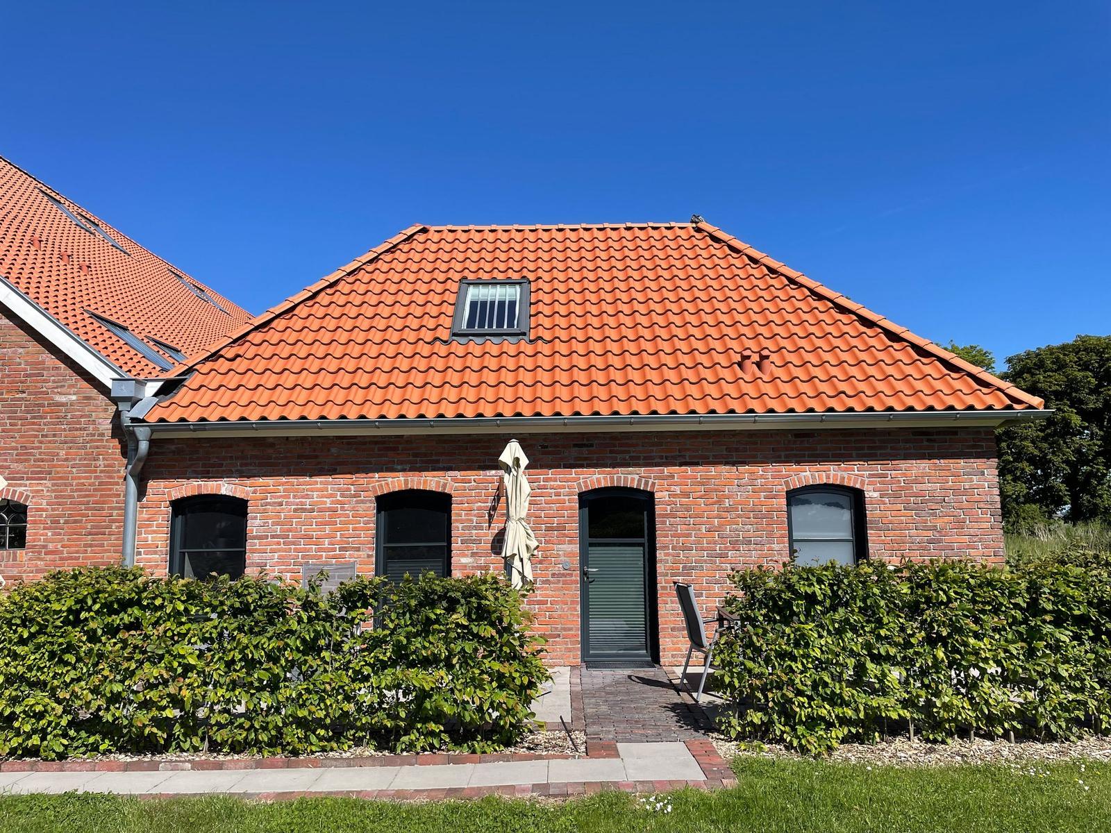 Ein Tischtennistisch steht in einem langen Innenhof mit Steinboden und Holzkonstruktion.