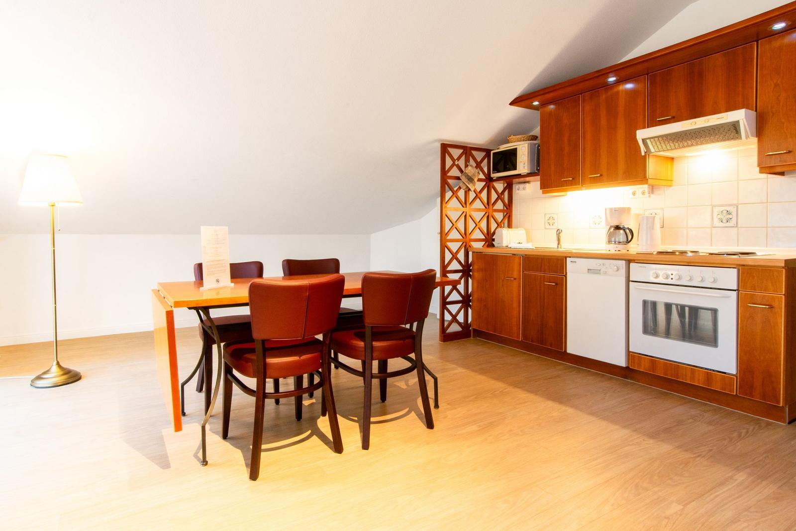 Wohnung mit Wohnzimmer, Schlafzimmer, Küche und Bad. Terrasse mit Holzverkleidung.