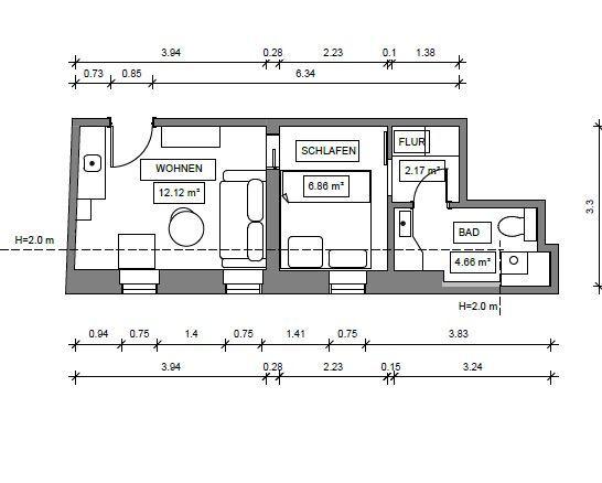 Empfangsbereich mit Holztheke, Sitzgelegenheiten und Glaswand. Decke mit Dachfenstern.
