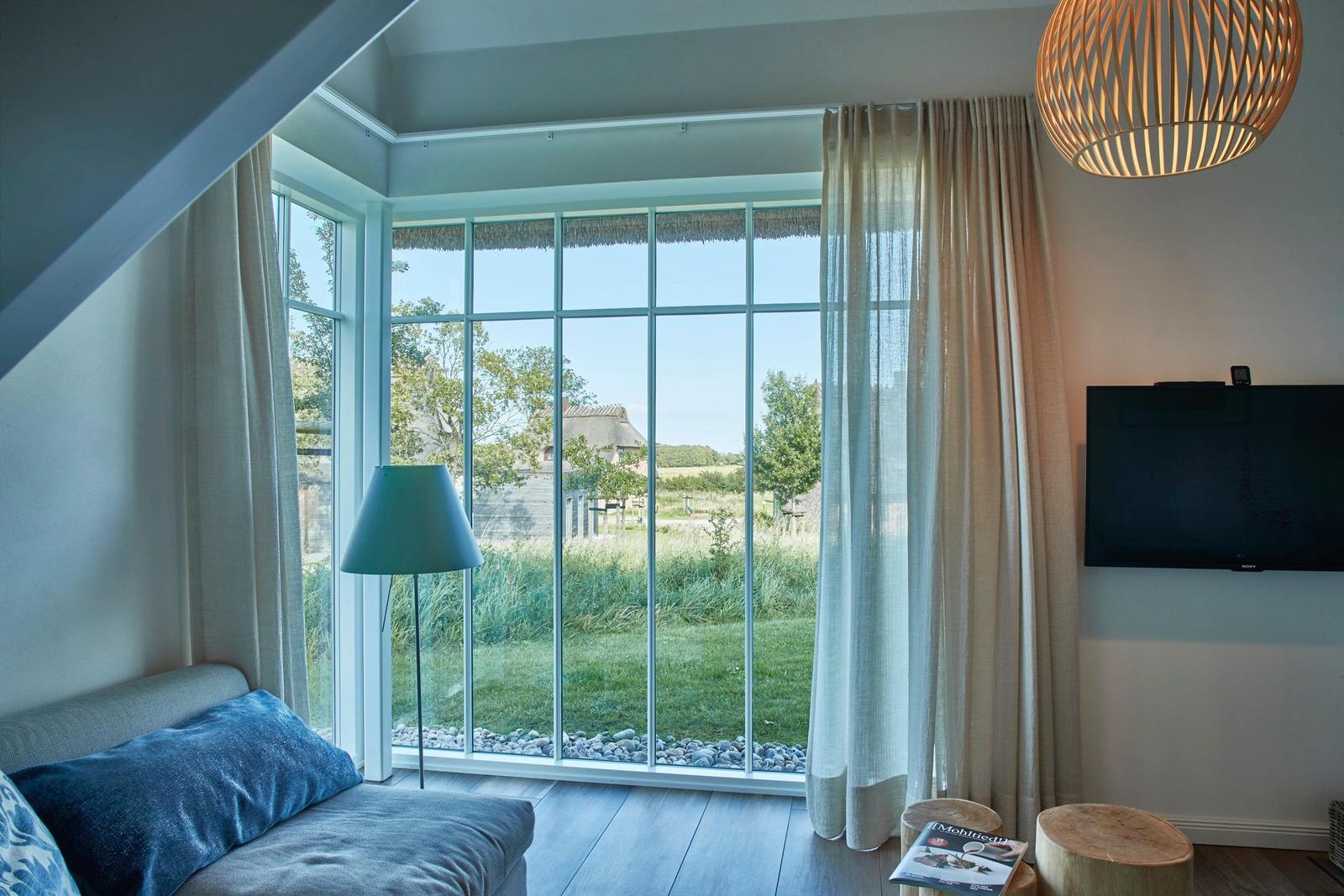 Schlafzimmer mit Holzboden, Bett mit blauer Bettwäsche und Nachttisch.