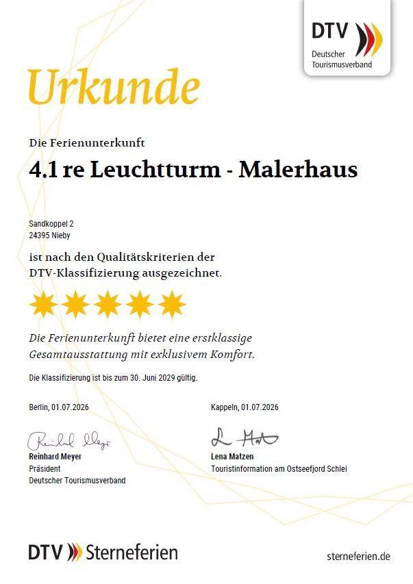 Essbereich mit Tisch, Stühlen und Küchenbereich im Hintergrund.