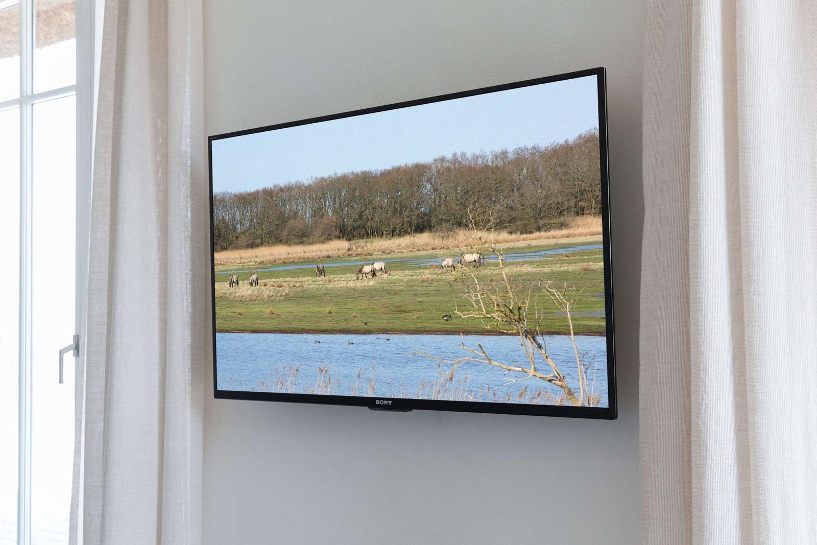 Holztisch mit Badematten, Badeeimer und Seife vor Fenster mit Rollladen.