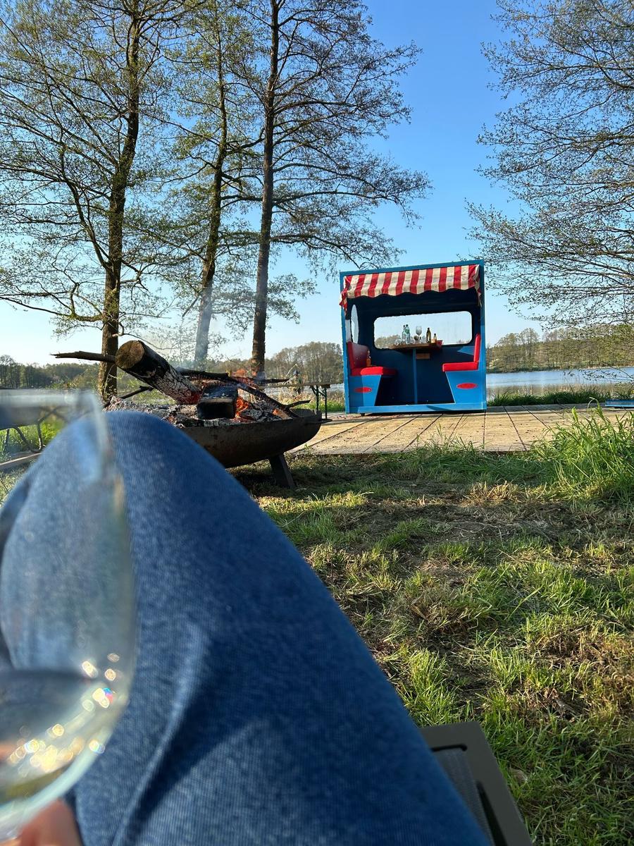 Ein Kind steht am Ufer eines Sees und blickt auf das Wasser.