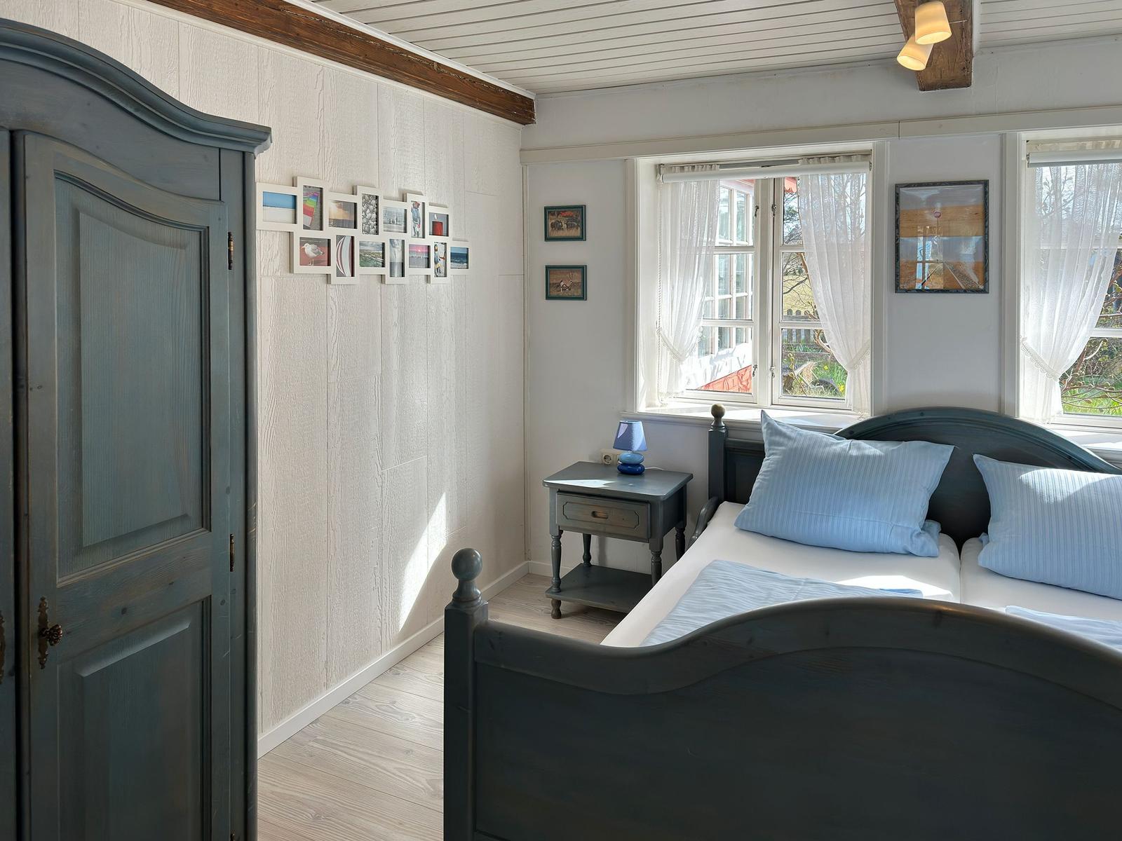 Schlafzimmer mit Bett, Spiegel und Tür zum Essbereich.