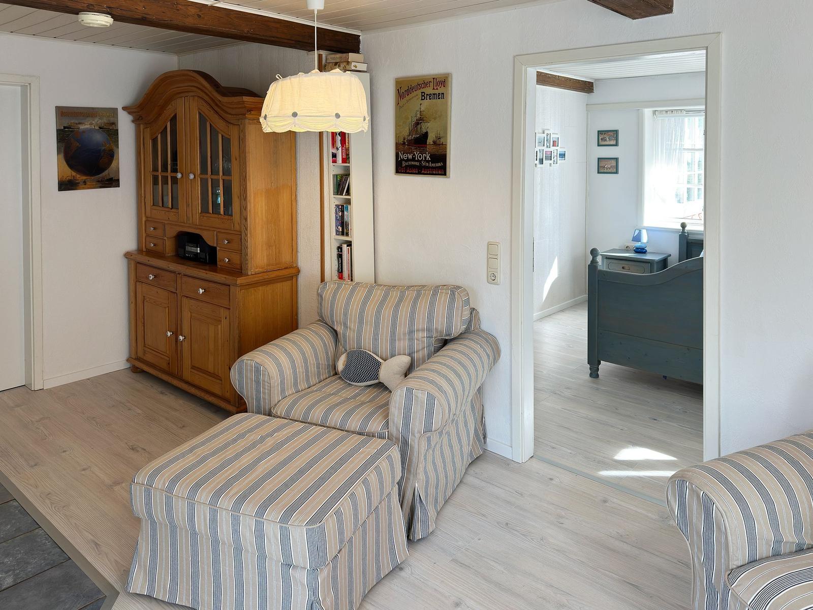 Schlafzimmer mit Bett, Nachttisch, Kleiderschrank und Fenstern.