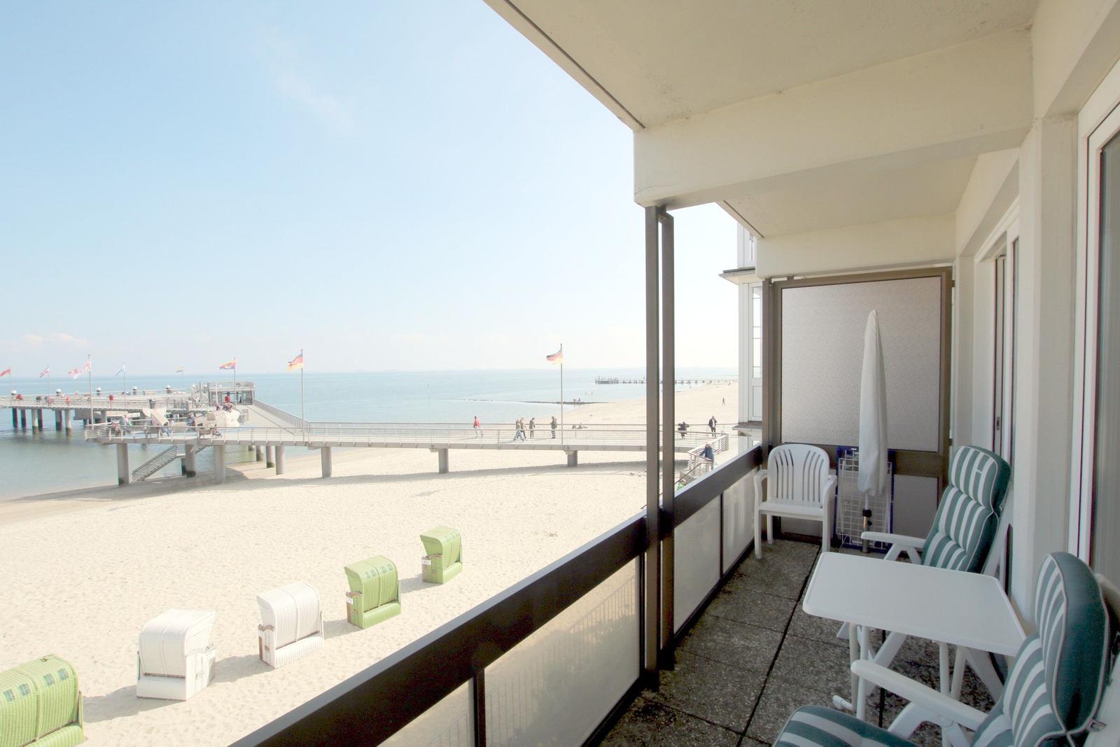 Schlafzimmer mit Bett, Wandbild und Fenster mit Vorhang.