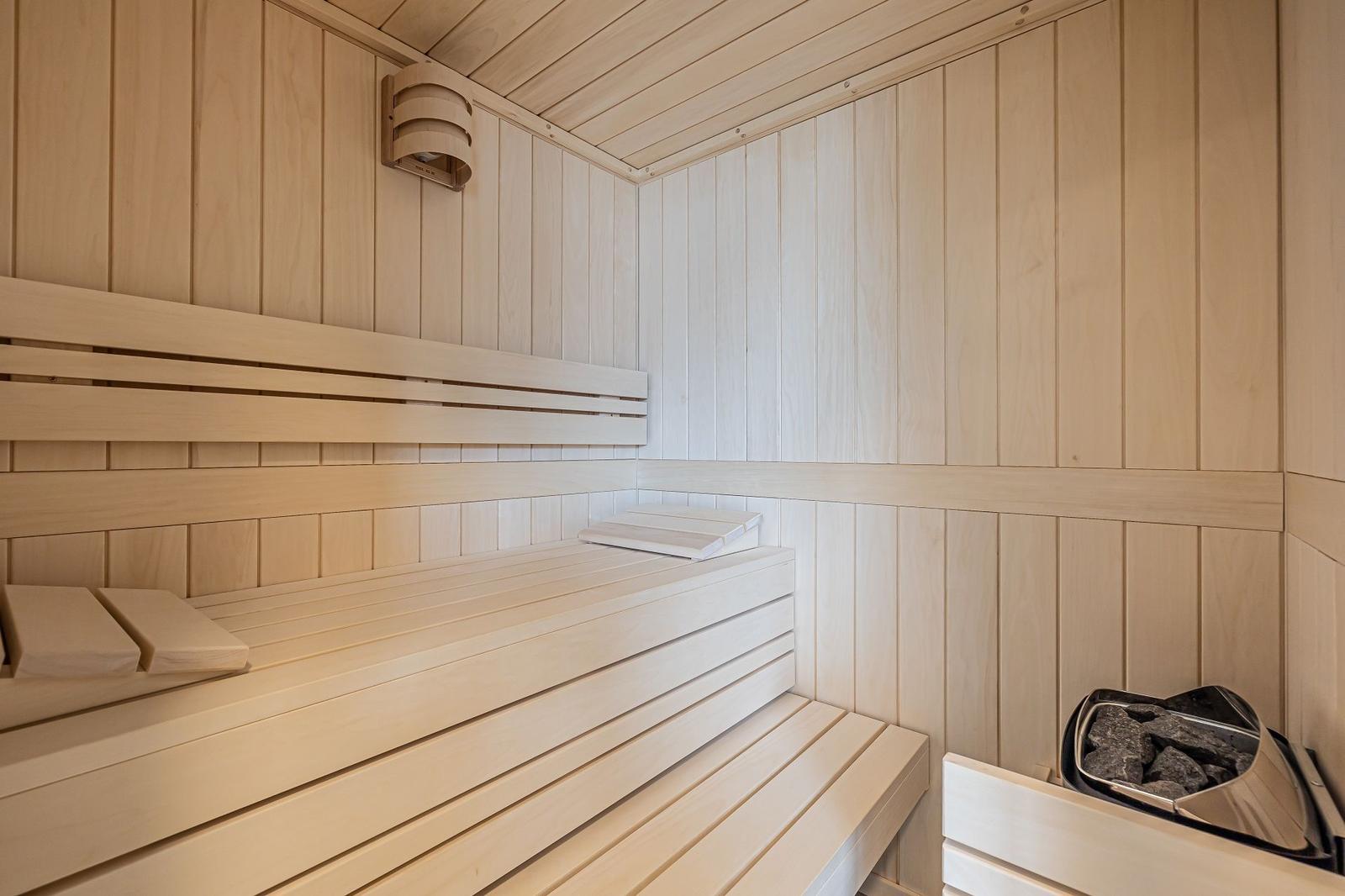 Bad mit freistehender Badewanne, Dusche und Waschtisch. Wanddekoration mit Fischmotiv.