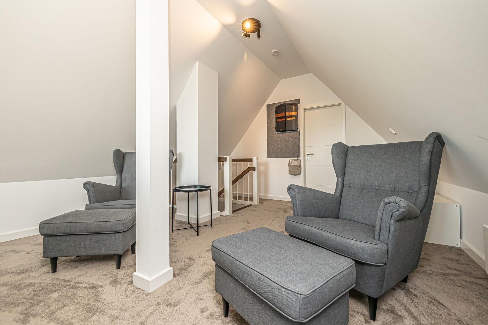 Moderne Ferienwohnung mit Steinmauer, Garten und gepflastertem Weg.
