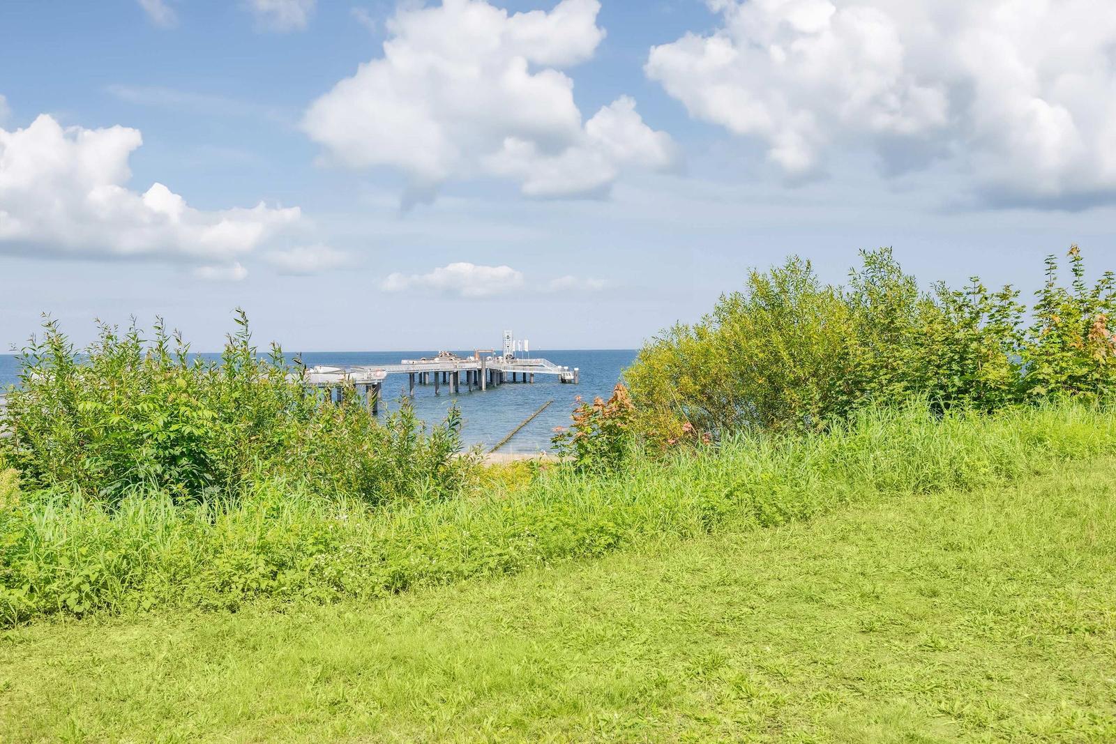 Zwei Boote liegen am Strand. Im Hintergrund ist eine Promenade mit Menschen.