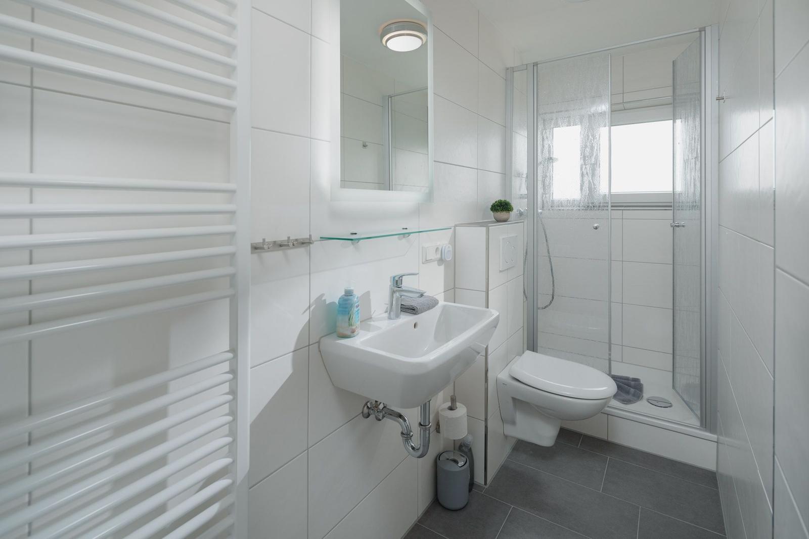 Wohnung mit Schlafzimmer, Küche und Bad. Holzboden und moderne Einrichtung.