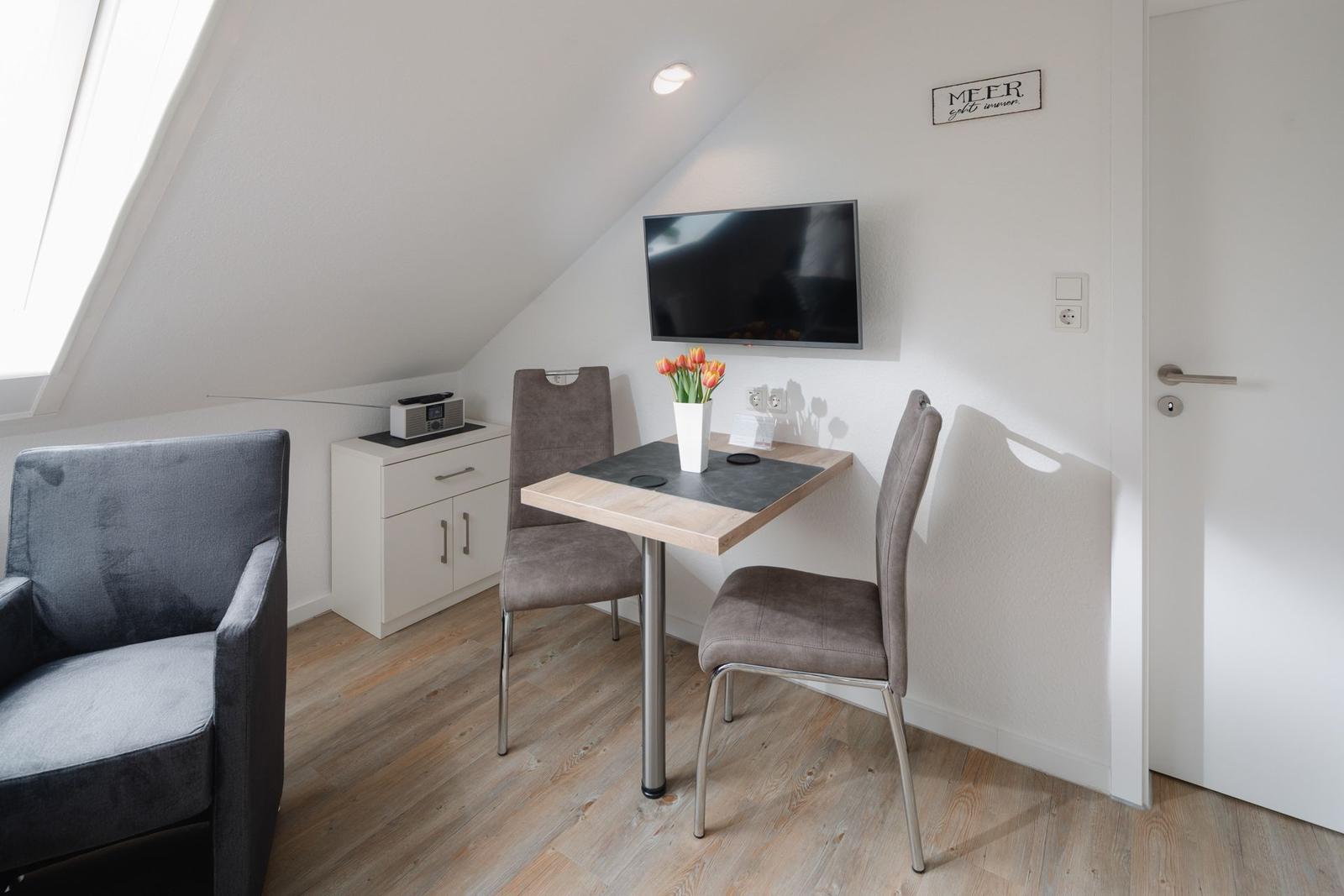Schlafzimmer mit Dachschrägen, Bett mit zwei Matratzen und Dachfenster.