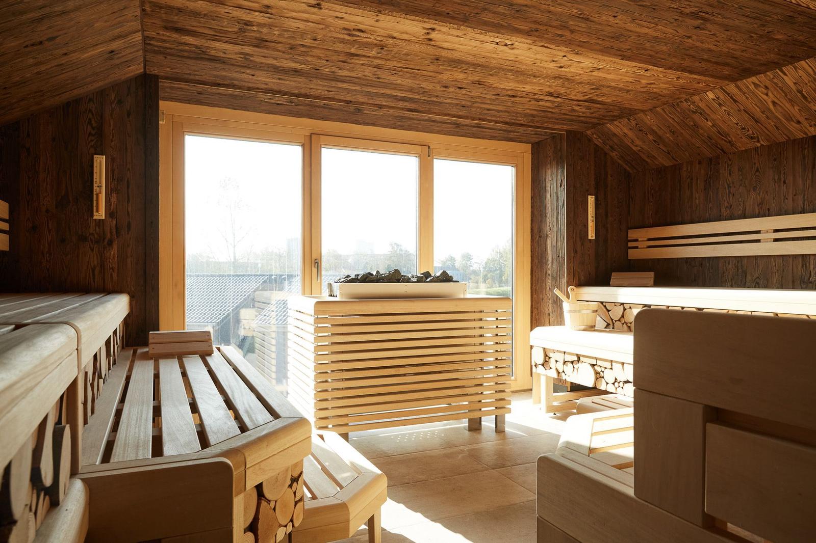 Sauna with wooden frame and stone basin. Background: window with wooden frame.