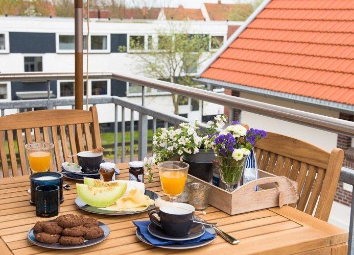Essbereich mit runder Tisch und Stühlen, Fernseher und Couch im Hintergrund.