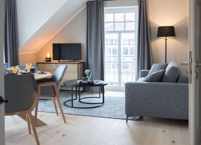 Schlafzimmer mit Dachschräge, Bett, Nachttisch und Wandlampe.
