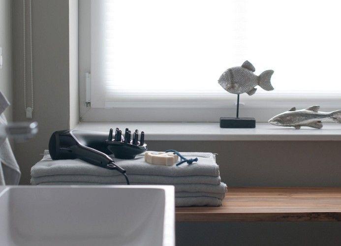 Schlafzimmer mit Bett, Stuhl und Nachttisch unter Dachschräge mit Fenster.