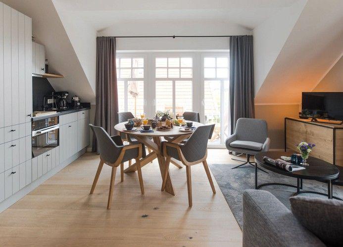 Schlafzimmer mit Dachschrägen, Bett, Stuhl und Nachttisch.