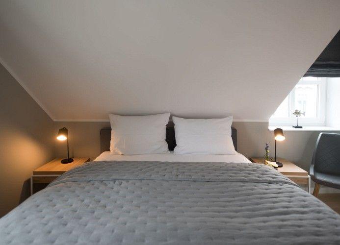 Schlafzimmer mit Dachschräge, Dachfenster und Bett mit Schublade.