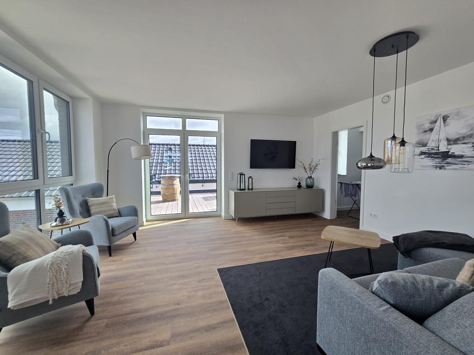 Esszimmer mit Tisch, Stühlen und großem Wandbild eines Segelbootes.