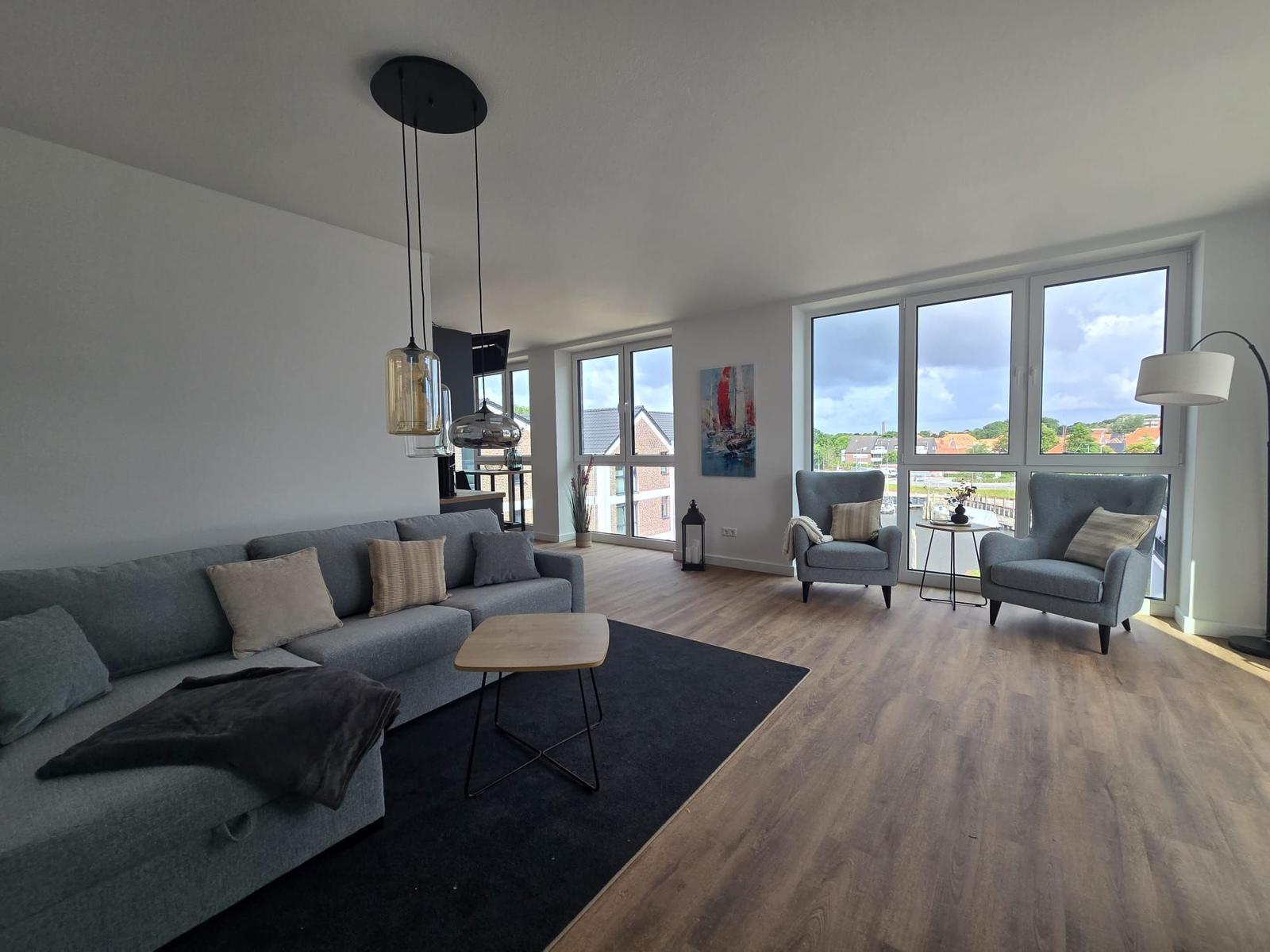 Eingangsbereich mit Spiegel, Sitzbank und Hakenwand. Durchgang zu Wohnbereich mit Fenster.