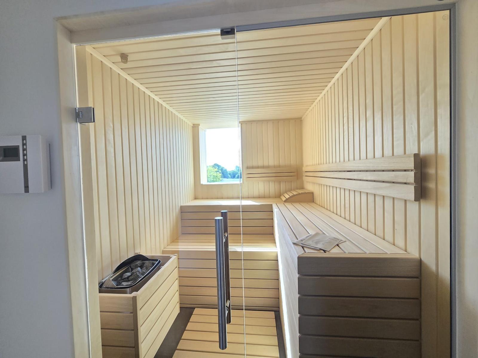 Schlafzimmer mit Doppelbett, Schreibtisch und großem Fenster mit Blick.