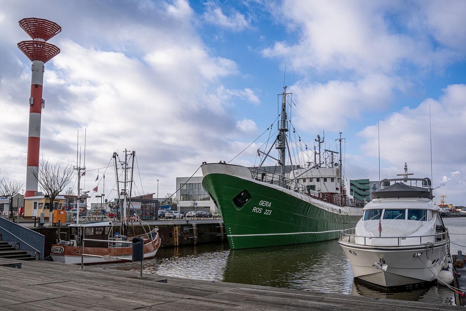 Rettungsring mit Kennzeichnung 50a an Steg, Hintergrund mit Booten und Leuchtturm.