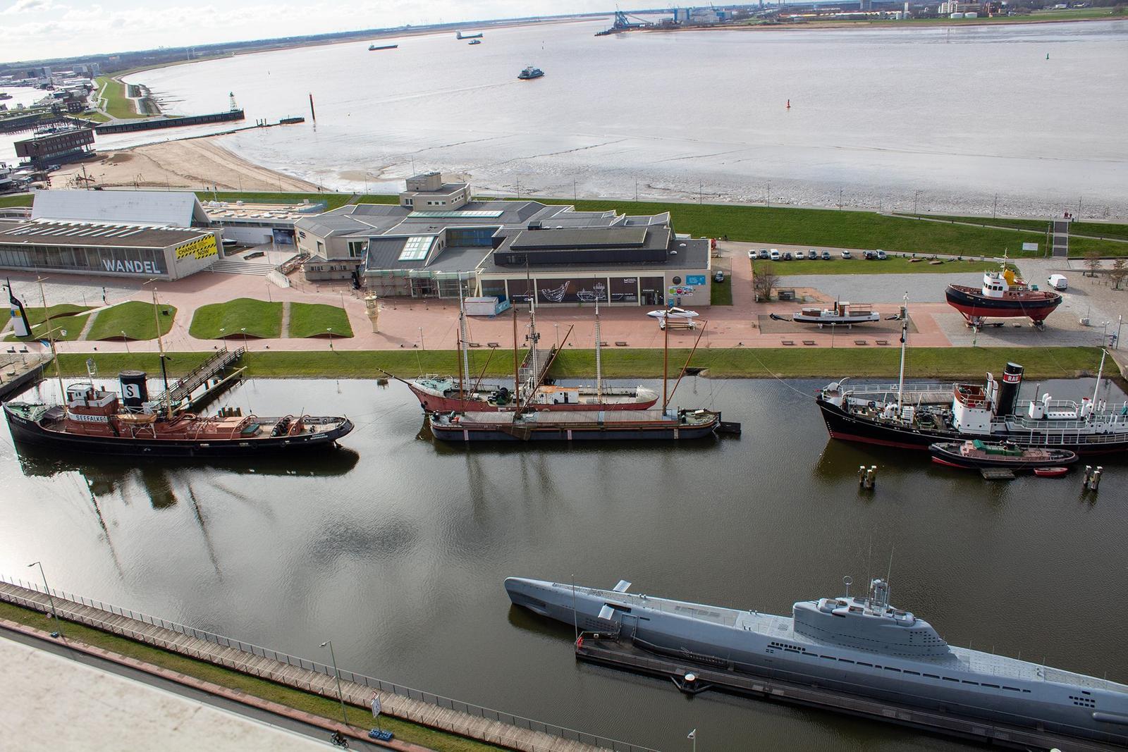 Ferrieschiff BREMERHAVEN liegt vor Anker. Strandkörbe und Dünen sind im Vordergrund.