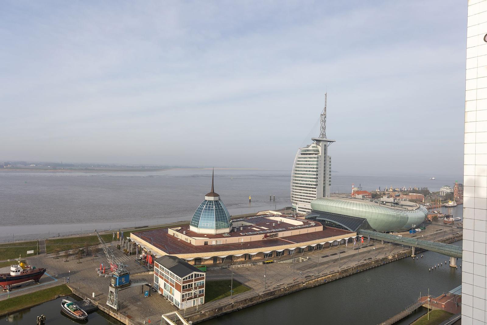 Das Schiff Deutschland mit deutscher Flagge liegt im Hafen. Im Hintergrund ist ein Segelschiff zu sehen.