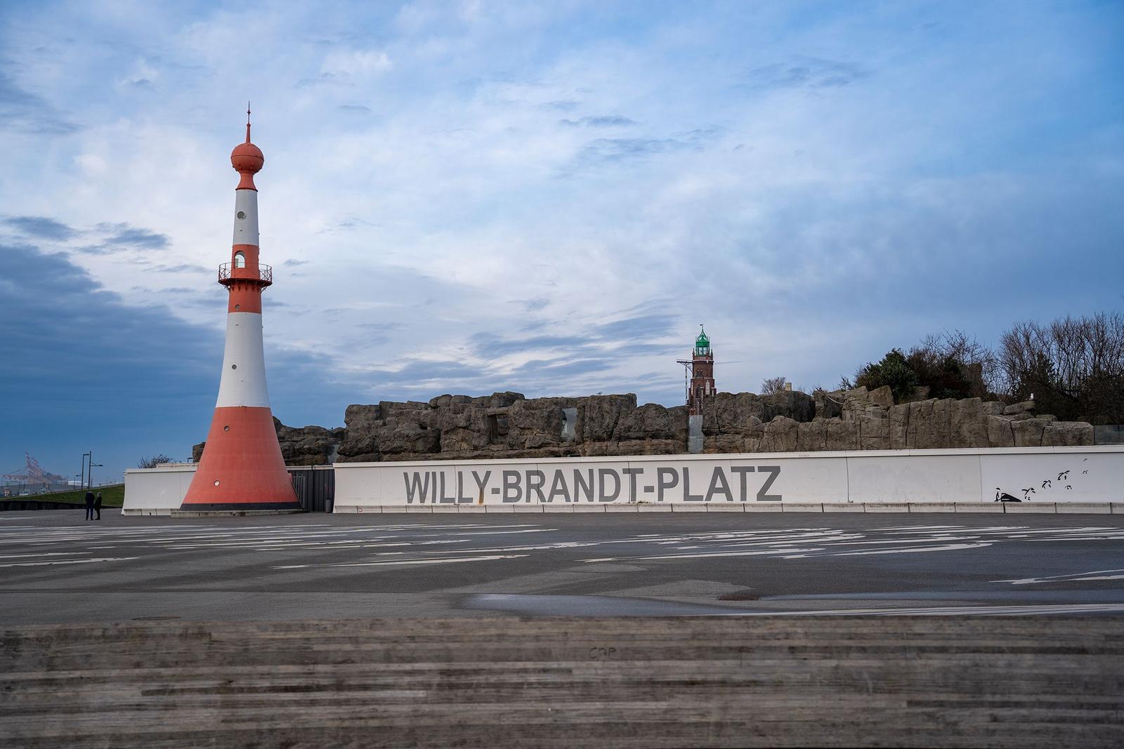 Rettungsring mit Kennzeichnung 50a an Steg, im Hintergrund Yachten und Leuchtturm.