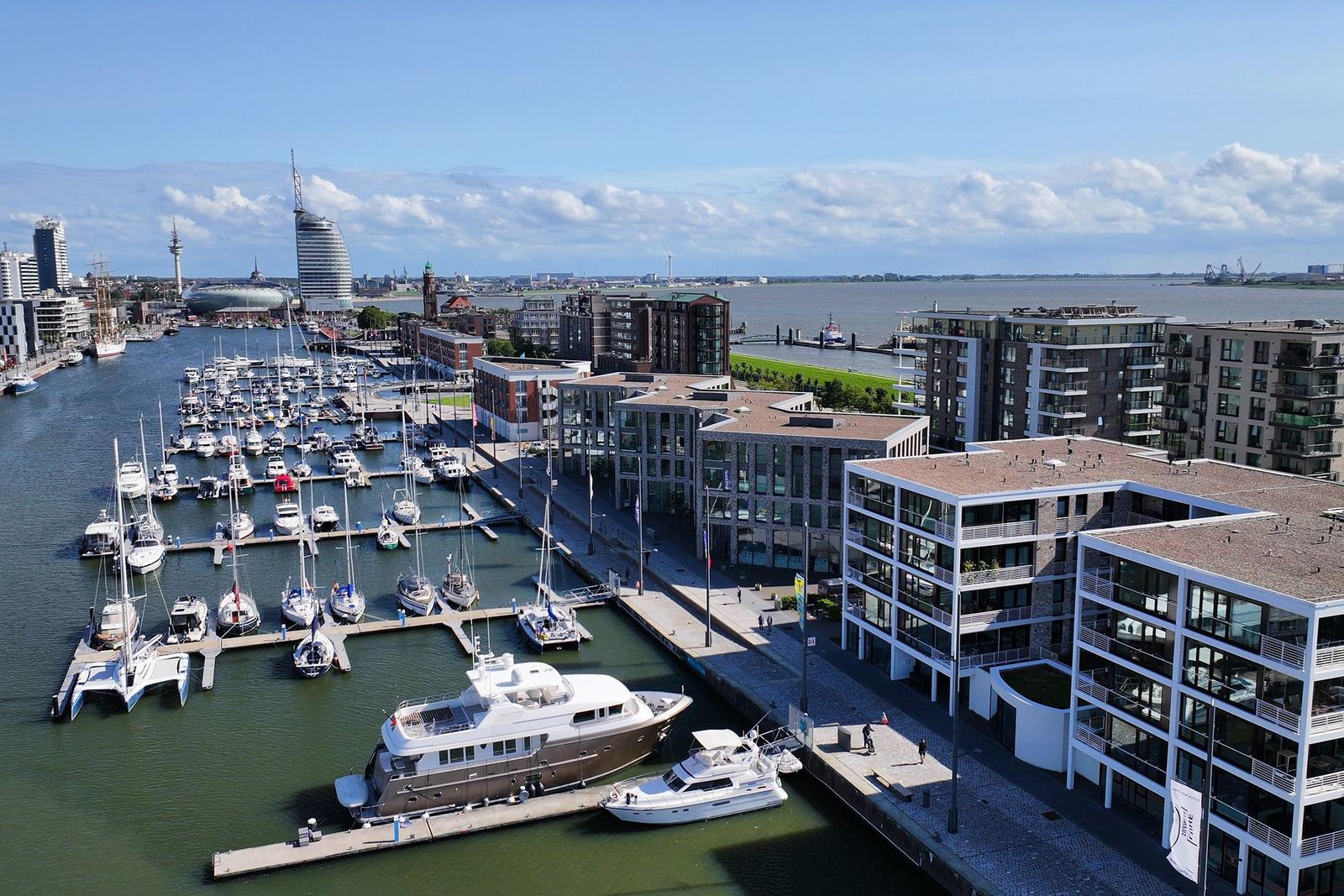 Modernes Wohngebiet am Hafen mit Booten und Grünflächen.