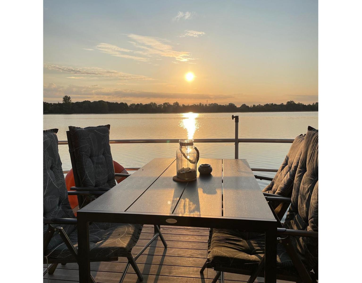 Sonnenuntergang über einem ruhigen See mit Spiegelung des Himmels.