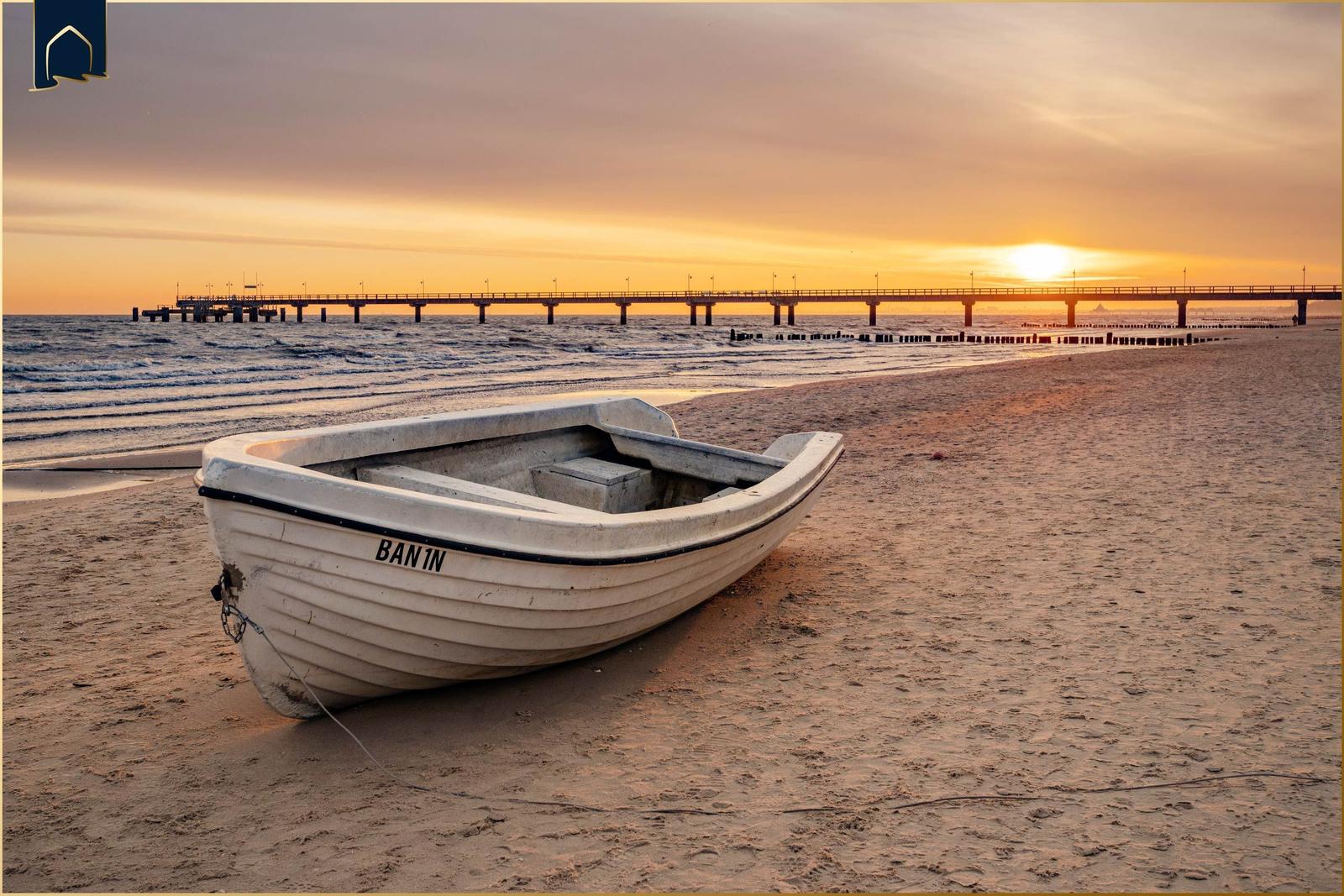 Holzweg durch Sanddünen zum Strand mit Boot.