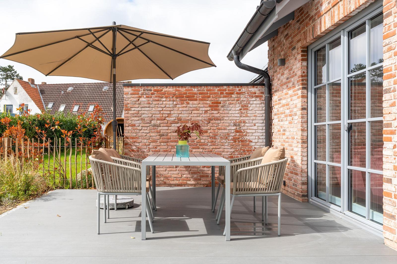 Haus mit Garten, Terrasse und Grillplatz. Modernes Design mit Holz- und Steinverkleidung.