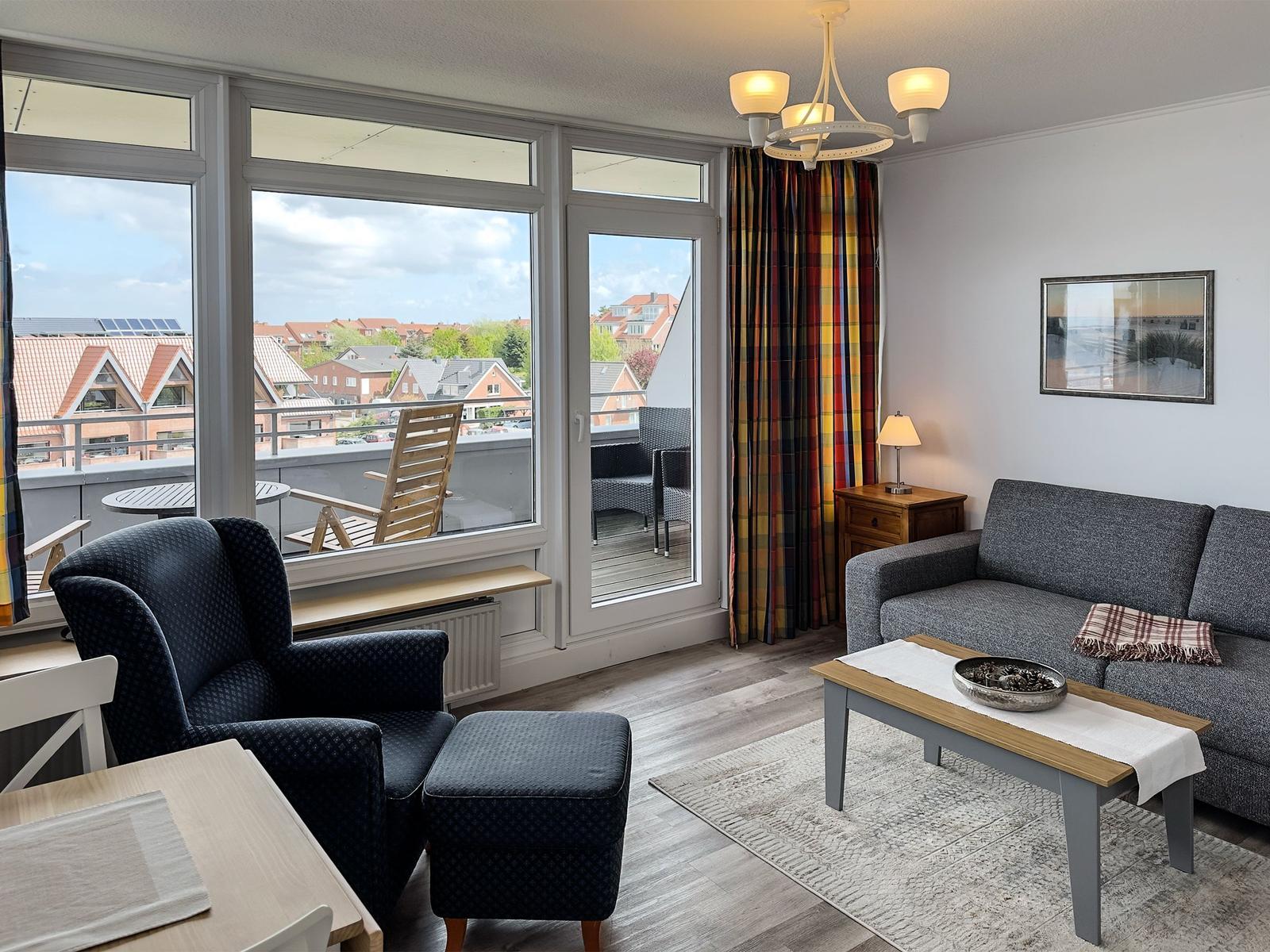 Wohnzimmer mit grauem Sofa, Holztisch und Wanddekoration.