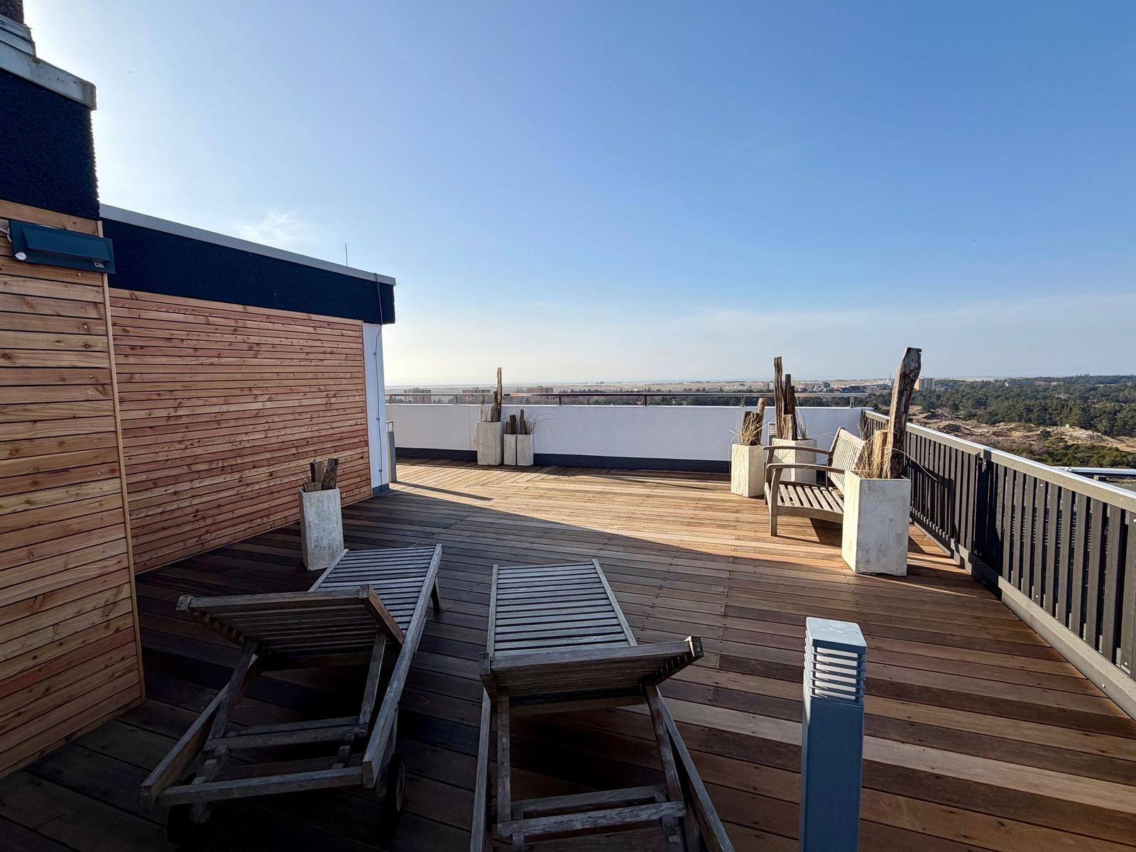 Terrasse mit Holztisch und Stühlen, Blick auf Landschaft