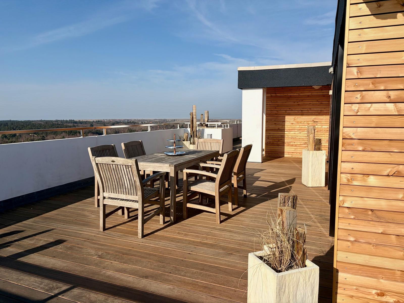 Schlafzimmer mit Bett unter Baldachin und Blick auf Balkon mit Liegestuhl.